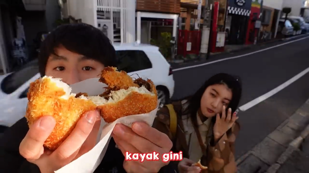 Gambar Tomo dan Hitomi Mencicipi Roti Goreng Isi Kari, Keju, dan Udang di Togoshi Ginza, Jepang (Sumber: Youtube Talent)