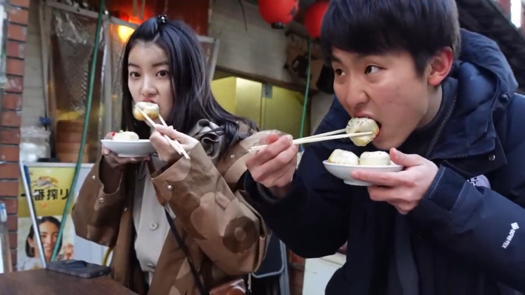 Gambar Tomo dan Hitomi Mencicipi Dumpling Isi Daging Berkuah di Toko Ryuki, Togoshi Ginza, Jepang (Sumber: Youtube Talent)